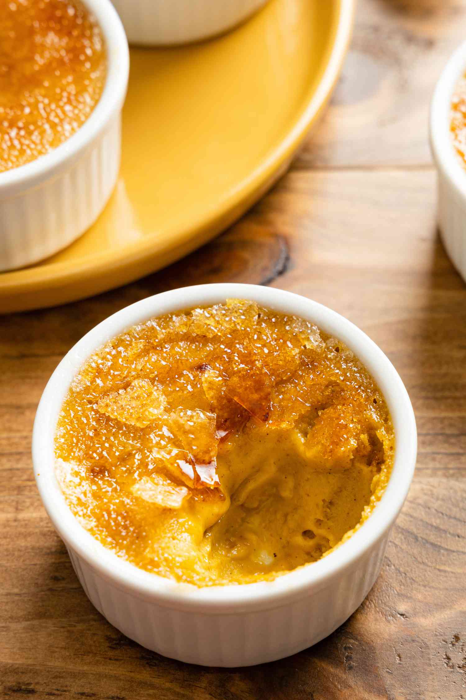 A 3-Ingredient Pumpkin Spice Crème Brûlée in a Ramekin, after Broken into with a Spoon