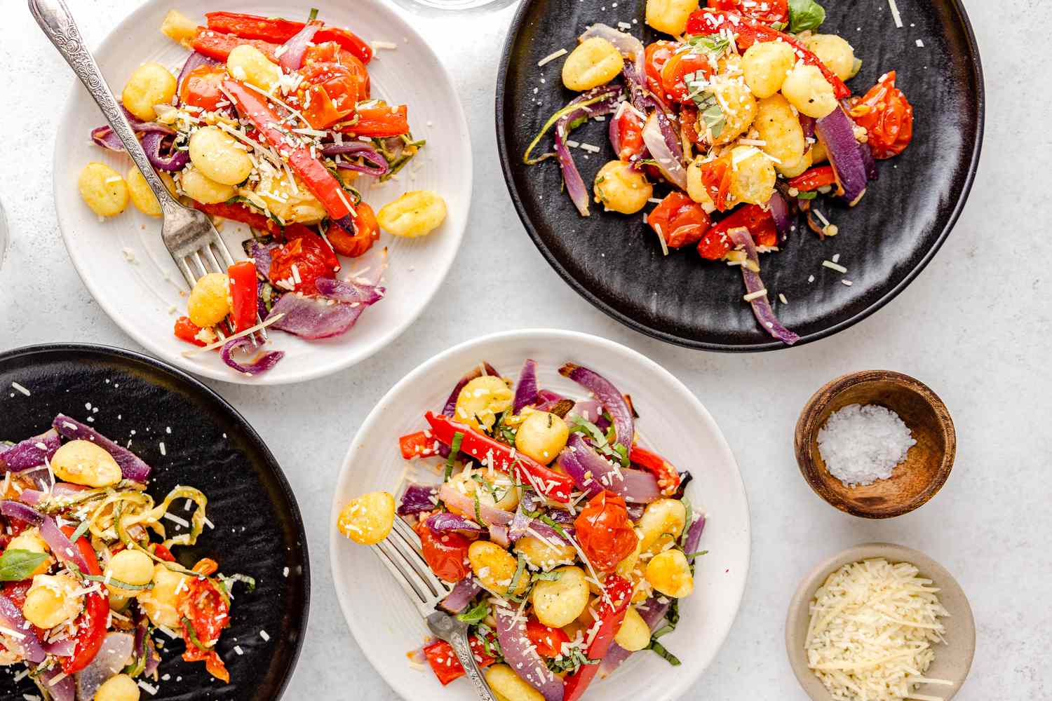 Sheet Pan Gnocchi With Zucchini, Tomatoes, and Bell Peppers Served on Four Plates