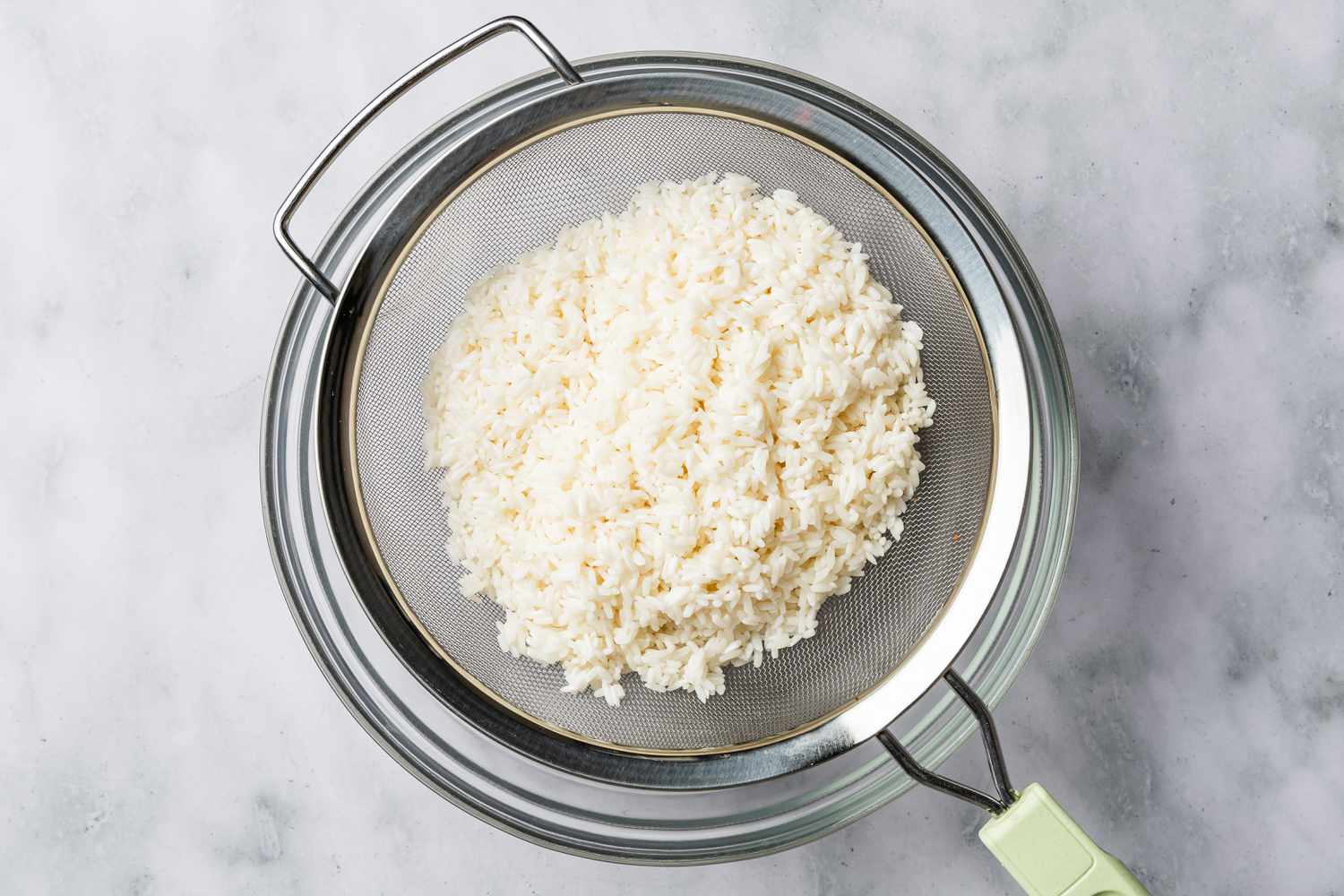 rice in a colander for biko (Filipino sticky rice cake) recipe