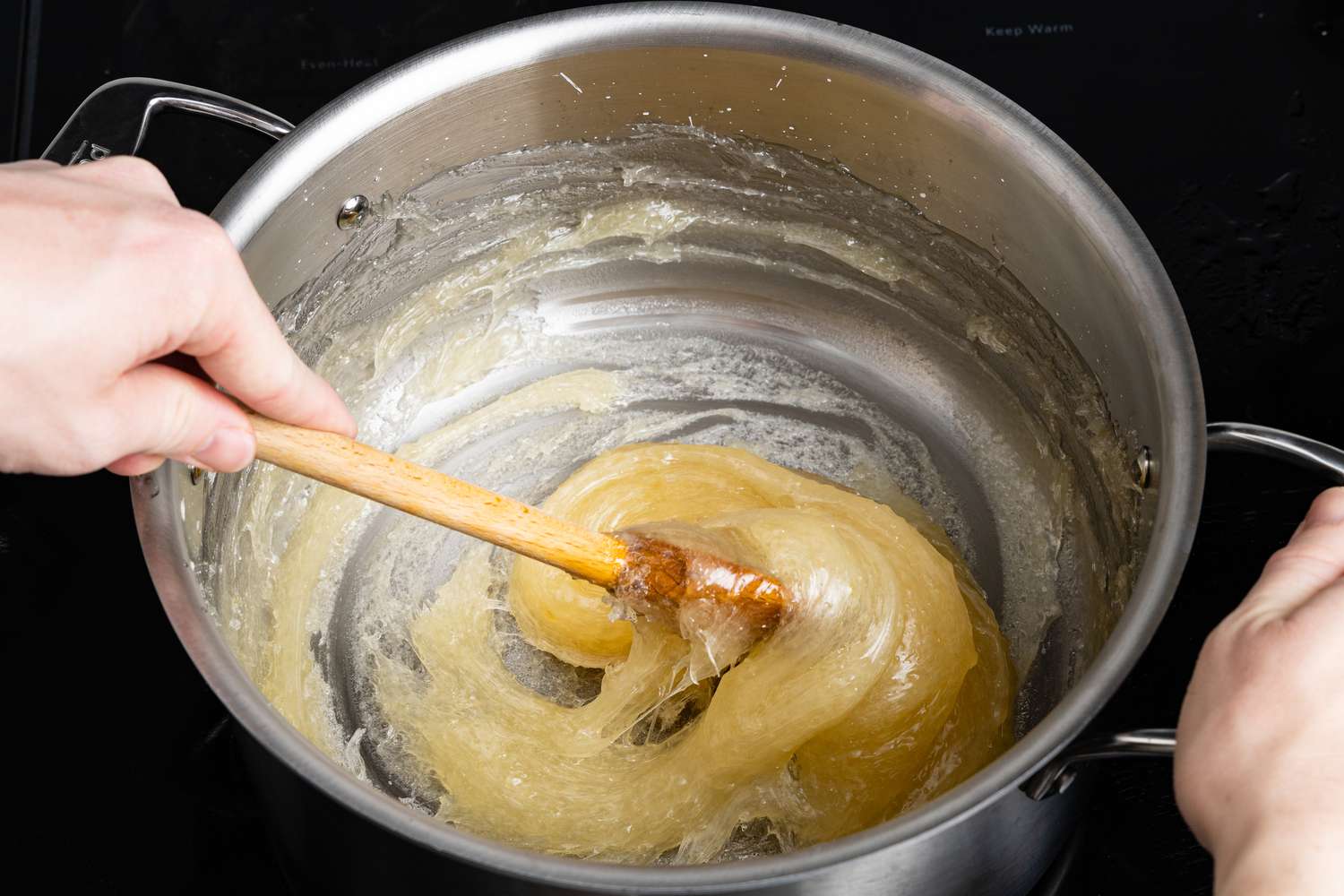 Wooden Spoon Continuing to Slowly Mix the Condensing Sugar-Cornstarch Mixture, Now a Light Golden Color, for Turkish Delight Recipe