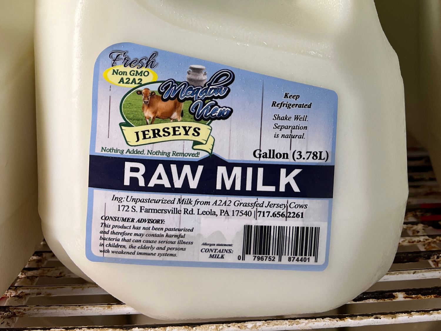 Gallon of raw milk with label Meadow View Jerseys displayed on a shelf