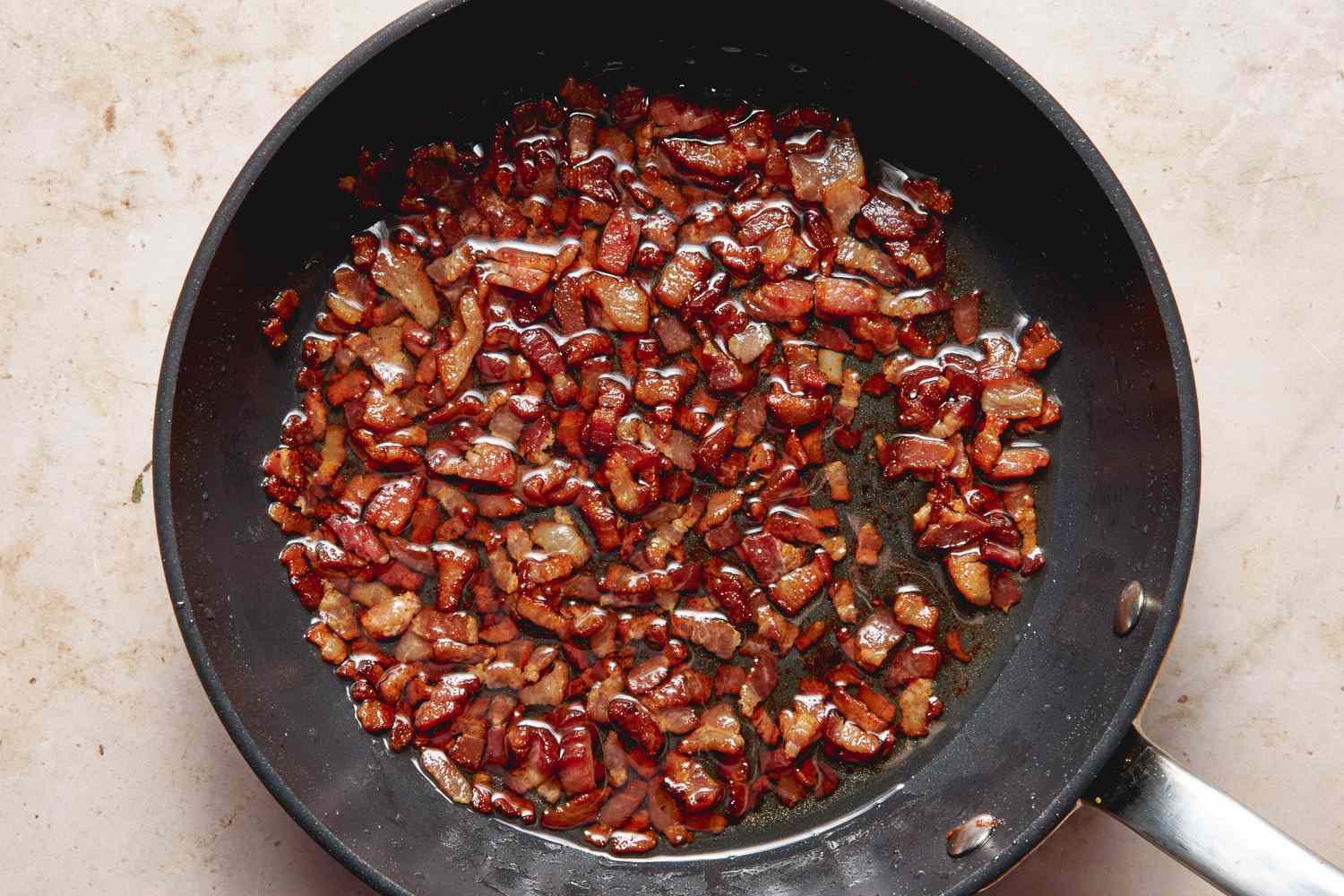 Skillet with cooked, chopped bacon for twice baked potatoes recipe