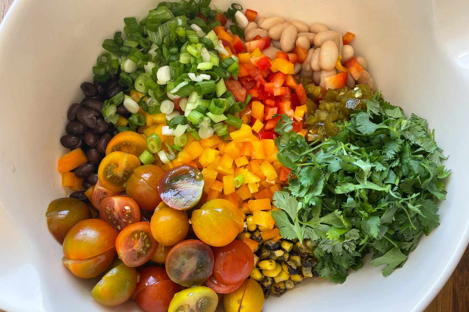 Ingredients (Halved Tomatoes, Cilantro, Corn, Black Beans, Bell Peppers, and Scallions) in a Bowl for Trader Joe’s Homemade Cowboy Caviar Recipe