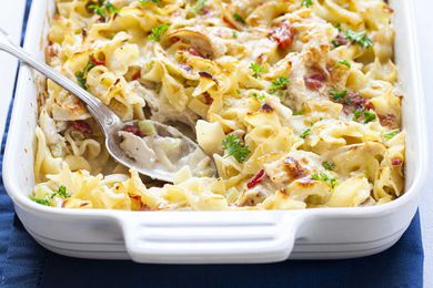Creamy Chicken Noodle Casserole in a white baking dish with a silver spoon.