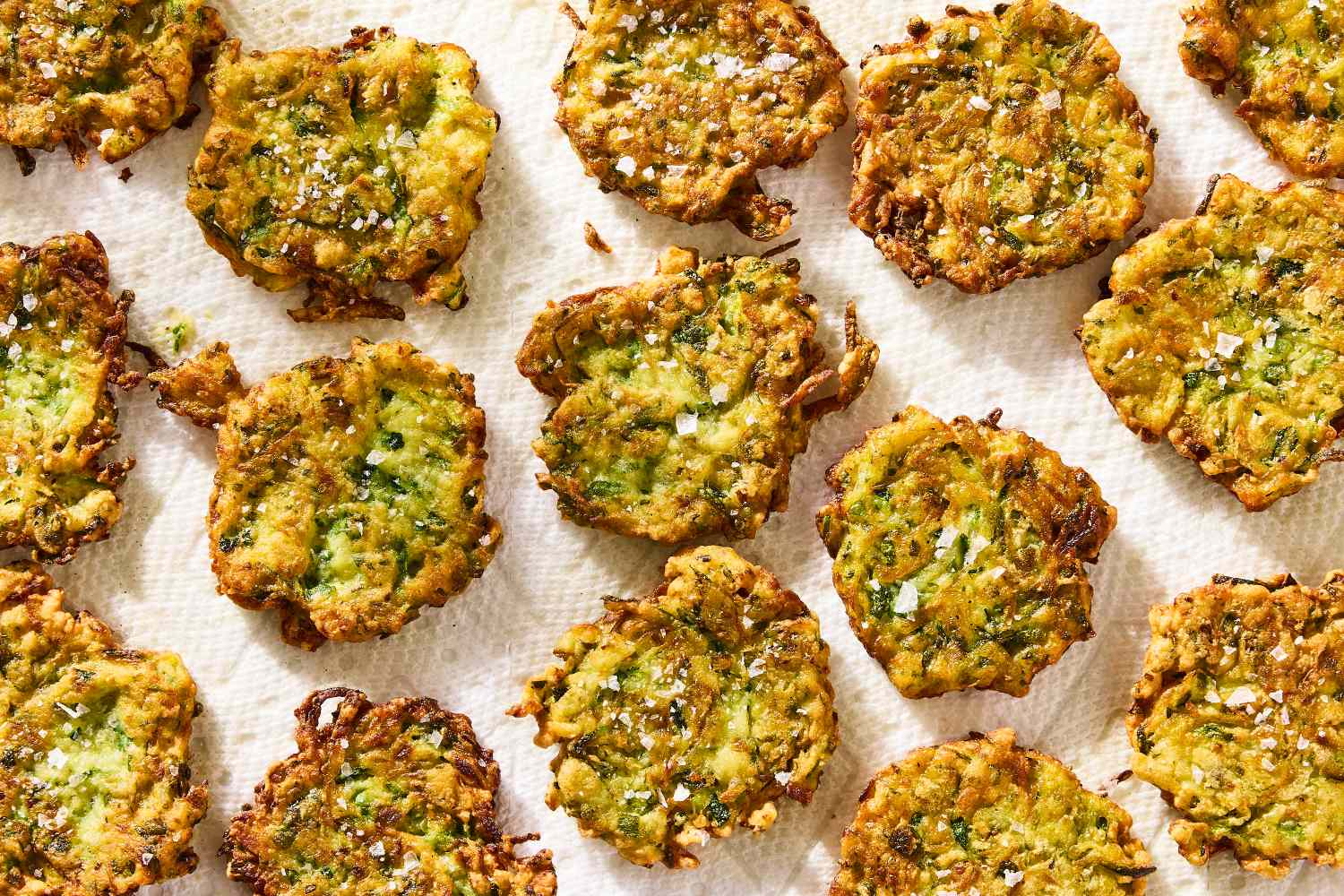 Zucchini fritters on a surface topped with sea salt