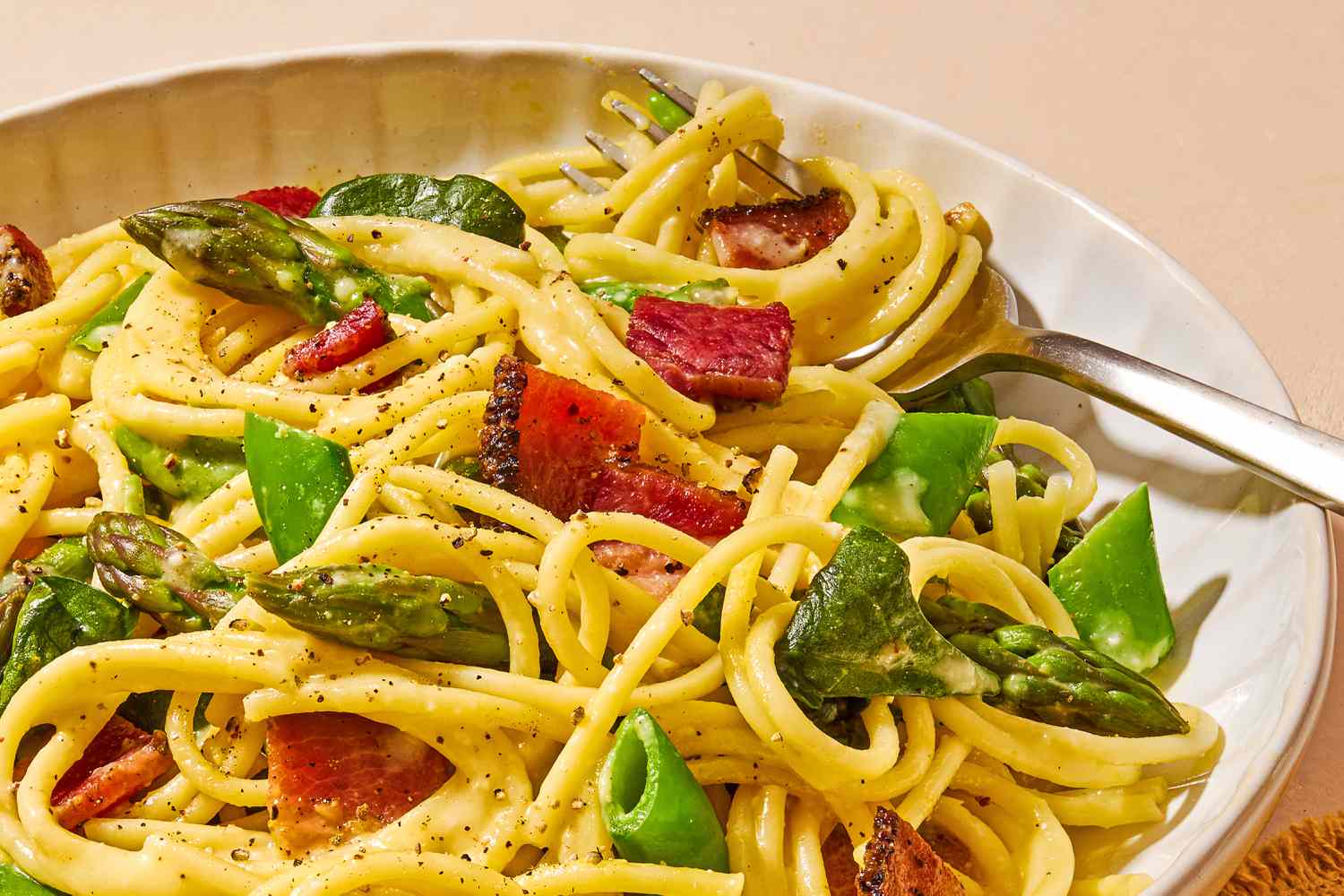 close-up of a plate of Spring Carbonara with a fork