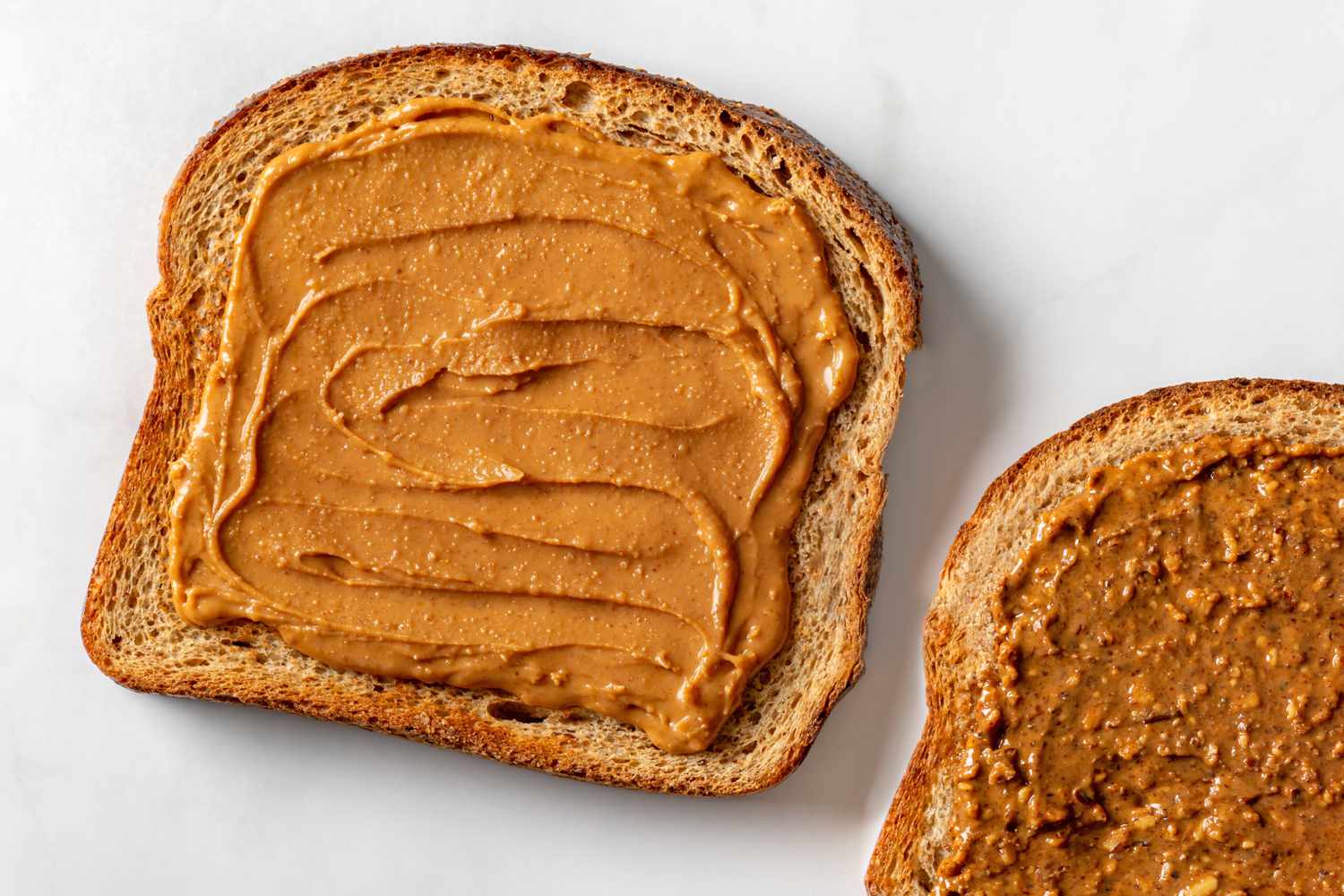 Overhead shot if two toast slices spread with almond butter