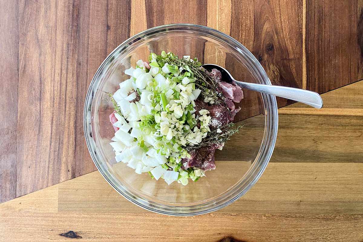 A mixing bowl with ingredients to make Jamaican Beef Stew.