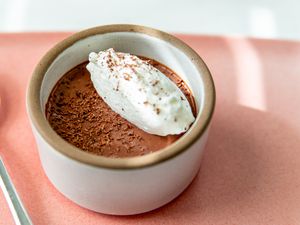 5-minute mousse in a cup with some whipped cream and shaved chocolate pieces