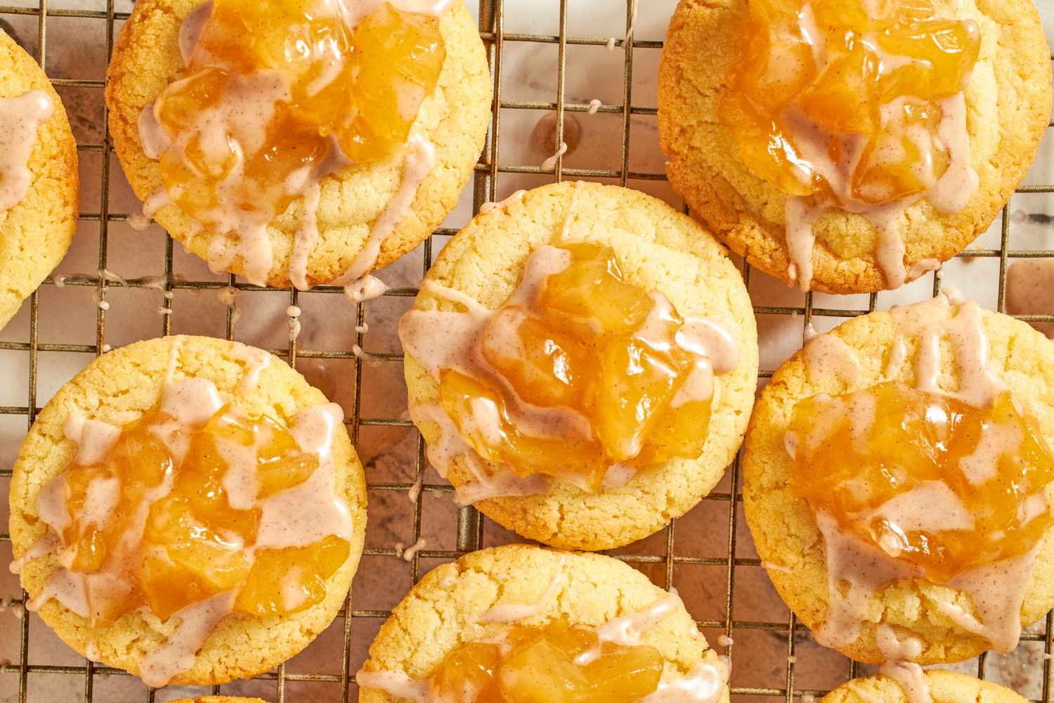 Baked cookies with an apple topping placed on a cooling rack