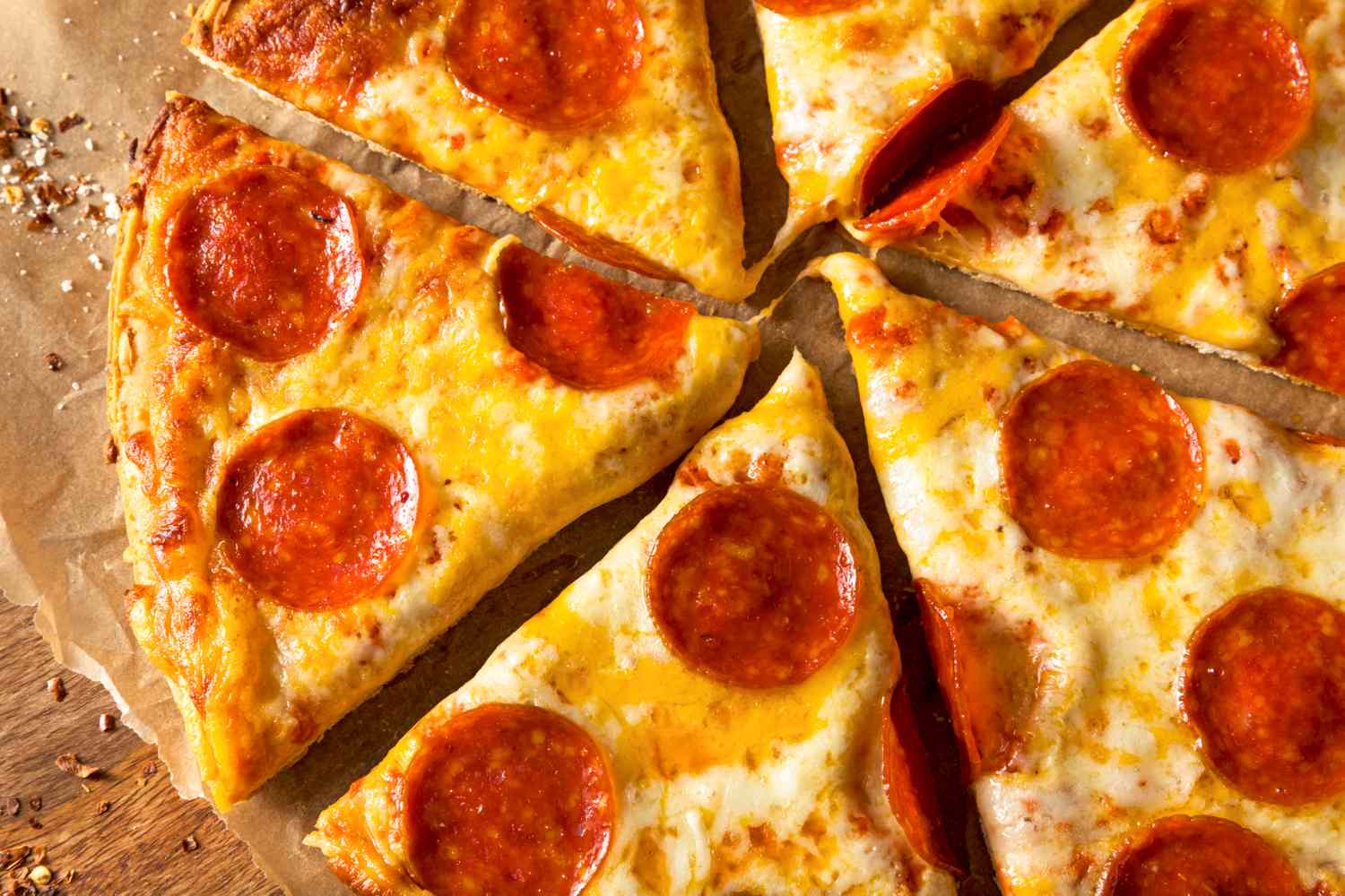Slices of cooked frozen pepperoni pizza arranged on a wooden surface