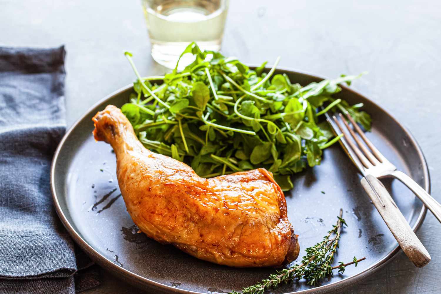 Plate with chicken confit and side salad.