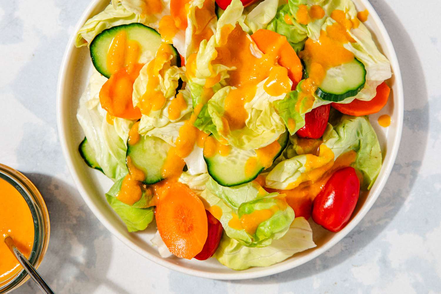 bowl of salad topped with carrot ginger dressing
