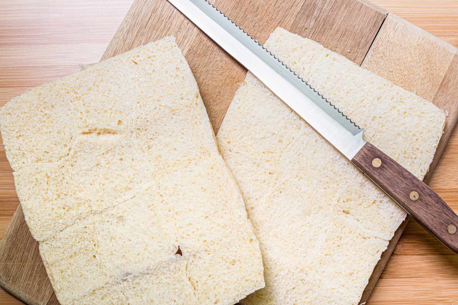 Dinner Rolls Halved for Hot Ham and Cheese Sandwiches on a Cutting Board