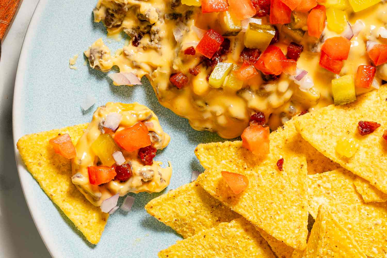 Nachos with a cheesebased dip topped with diced vegetables