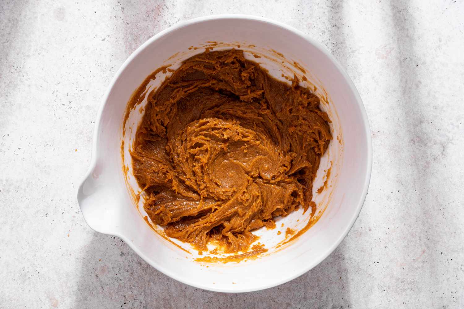 Bowl of wet ingredients after whisked together for monster cookie recipe
