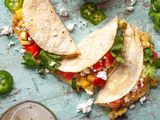 Overhead view of three vegan tacos with vegetables visible in the tacos.