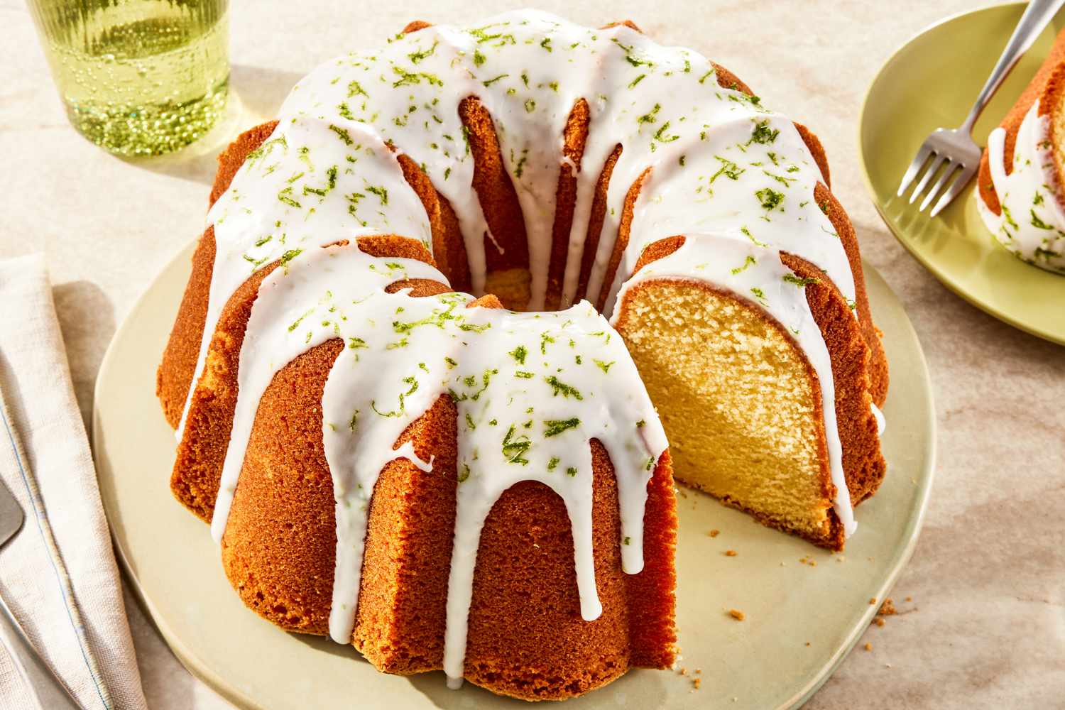 7UP bundt cake on a plate at a table setting with a glass of soda and a plate with a serving 