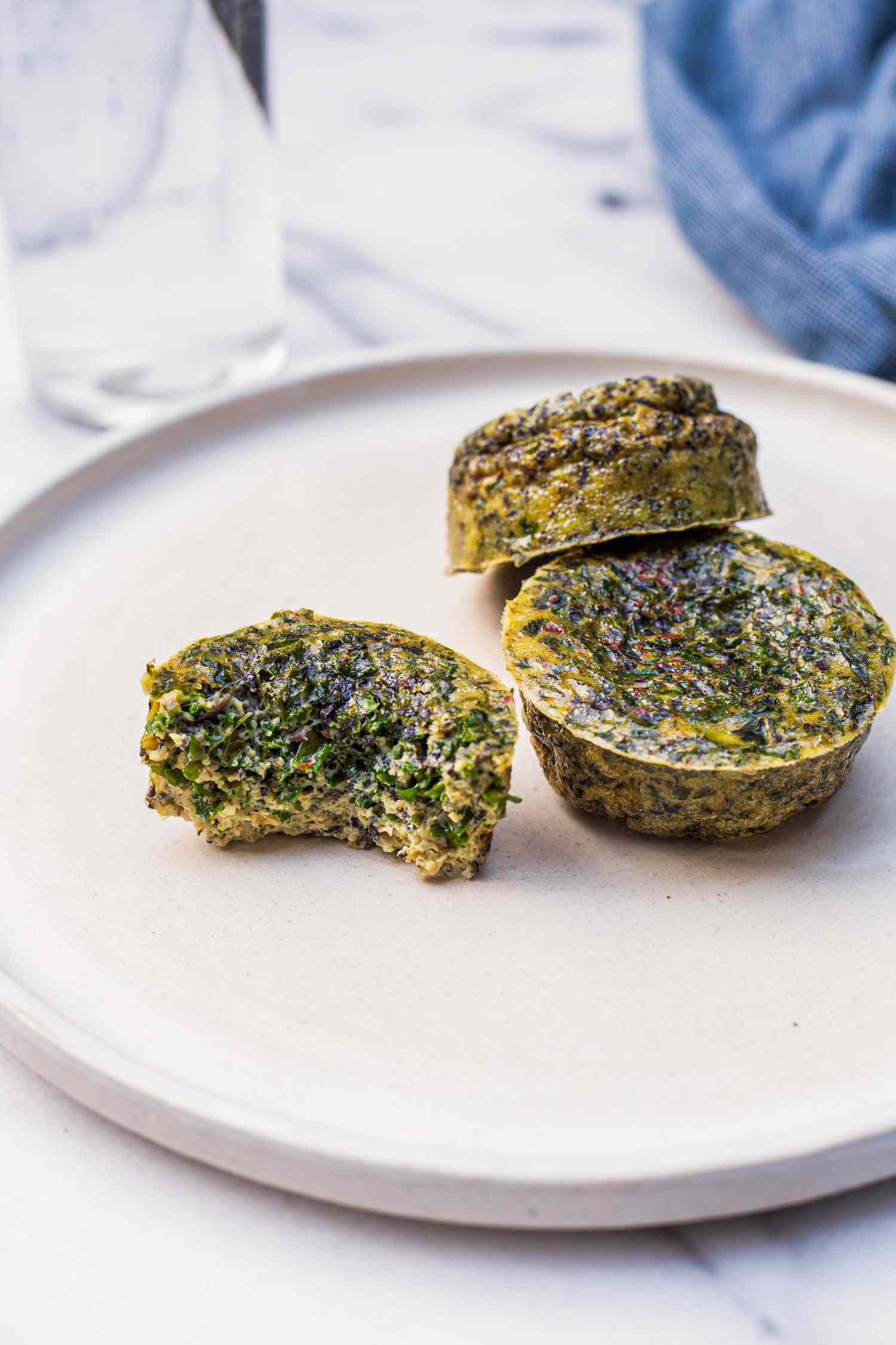 Kale and Portobello Egg Bites on a Plate with One Bitten 