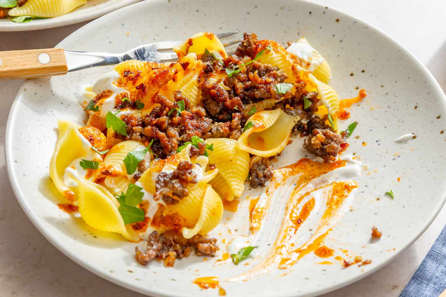 Turkish pasta dish with shell pasta, ground meat, and yogurt on a plate