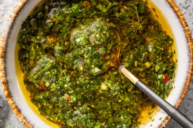A bowl of chimichurri with a spoon in it