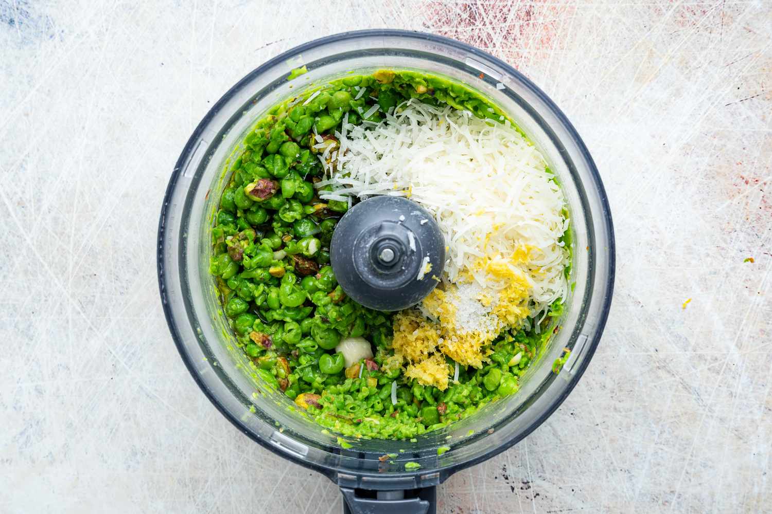 Lemon Zest and Pecorino Romano Cheese Added to Food Processor for Italian Pea Pesto Recipe 