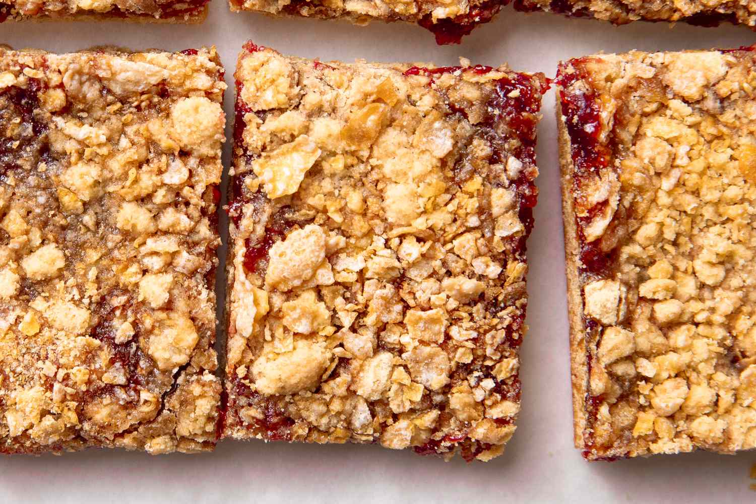 Crispy topped raspberry jam bars arranged in close up view