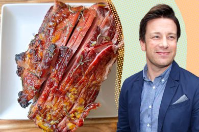 Jamie Oliver next to a sliced glazed ham with rosemary