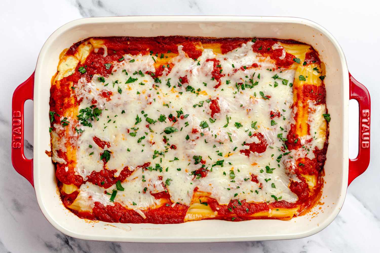 Casserole Dish of Cooked Manicotti Topped With Chopped Parsley