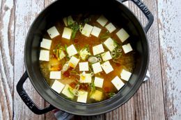 Tofu added to miso soup to make a miso soup with sesame oil and togarashi