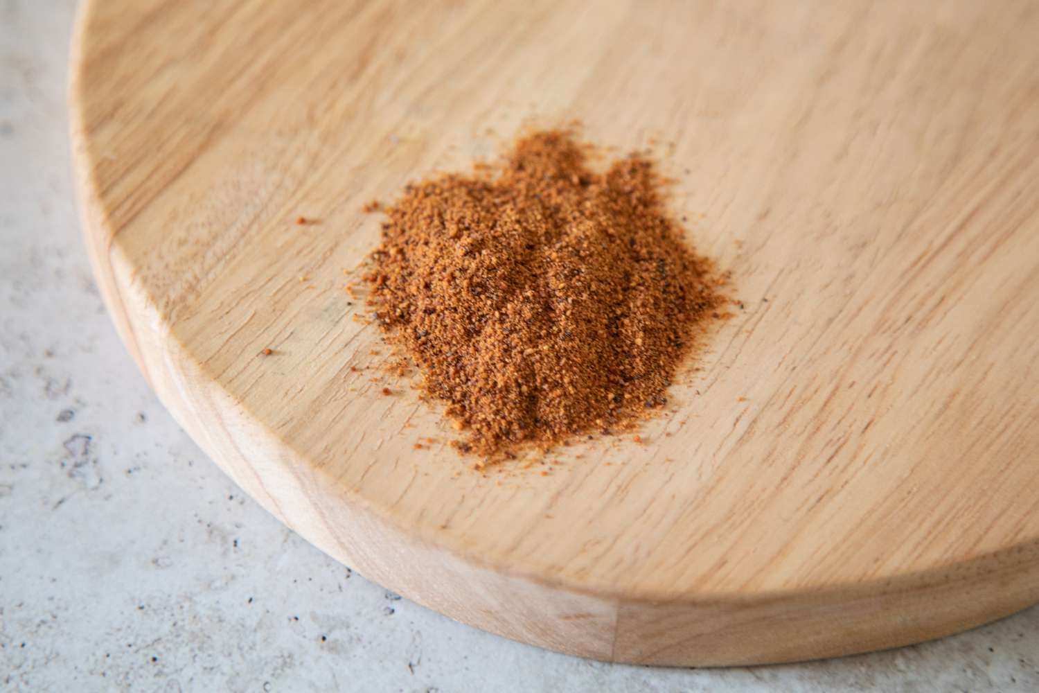 Pile of ground nutmeg on a wood serving platter