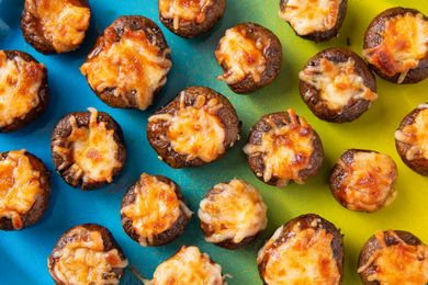 Baked stuffed mushrooms topped with melted cheese displayed on a colorful background