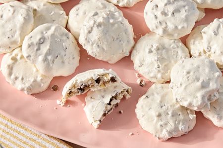 A plate of forgotten cookies with one broken in half to show the inside