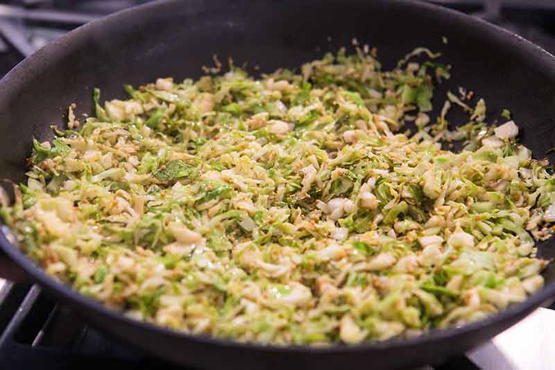 shaved brussels sprouts in a skillet with lemon and wine
