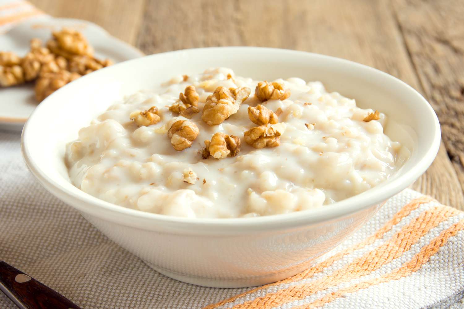 oatmeal in a white bowl topped with walnuts