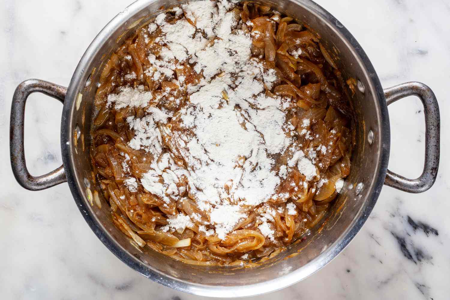 Add flour to the caramelized onions.