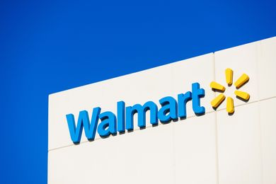 The Walmart logo on a building against a blue sky