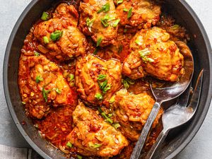 Smothered and covered chicken and gravy in a skillet.
