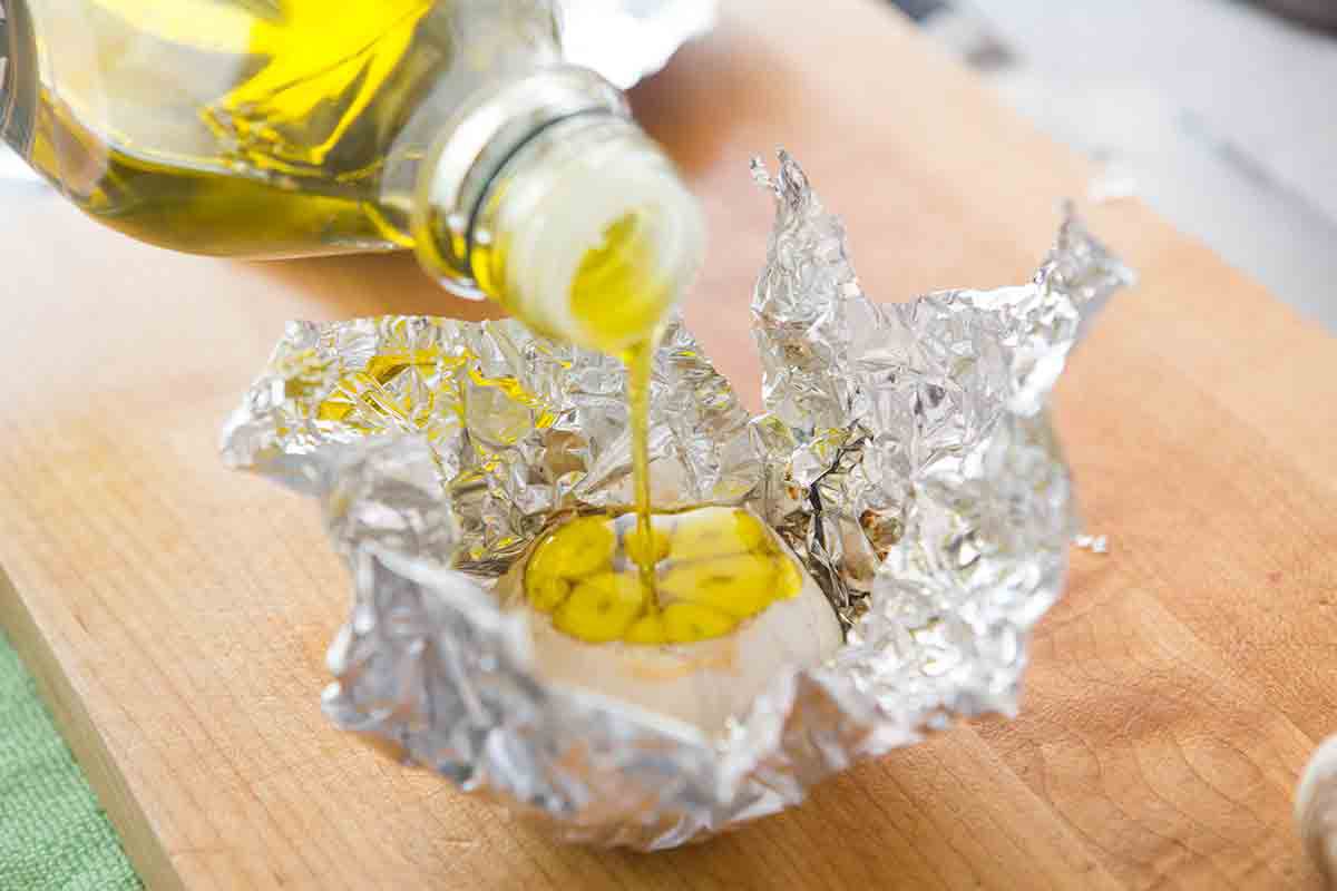 slice top off of garlic head, pour over with olive oil