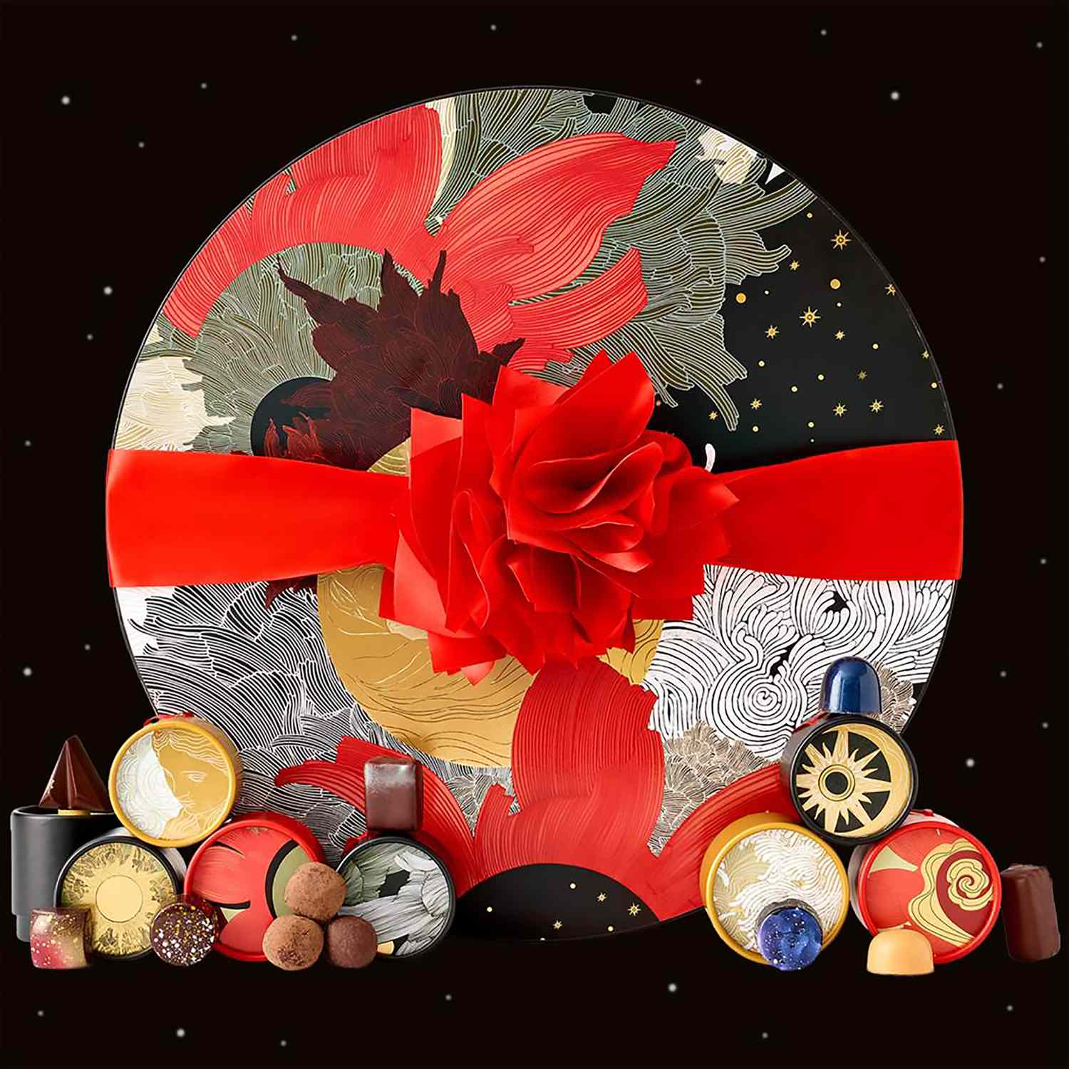 Circular holidaythemed gift box with decorative chocolates surrounding it featuring a red bow