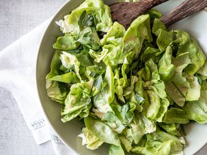 Bowl of Green Salad with Fresh Herbs and Red Wine Vinaigrette with Serving Utensils