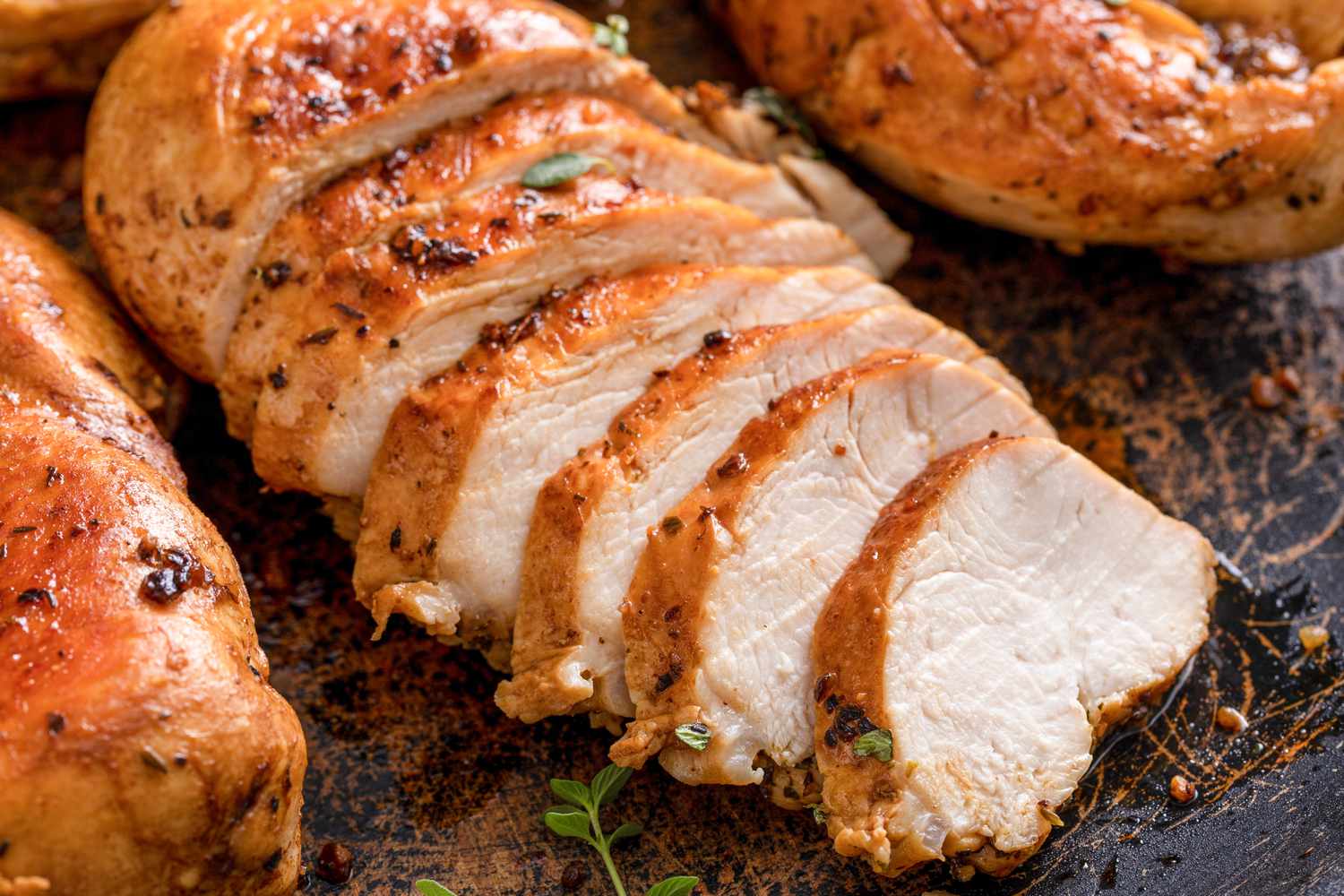 cooked chicken breast sliced into pieces on a plate