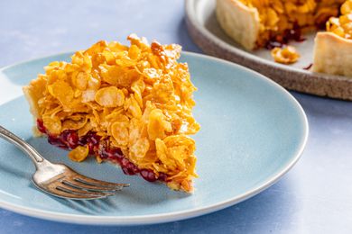slice of cornflake tart on a plate and in the background, the rest of the tart on a plate