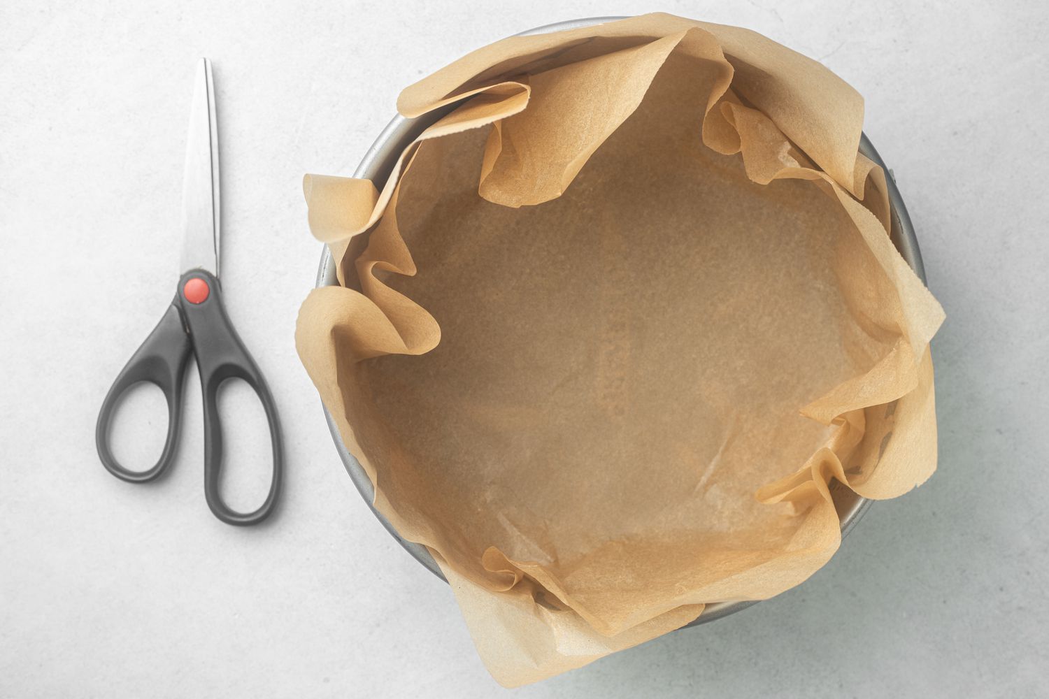 Lining a pan with parchment to make a basque-style cheesecake.