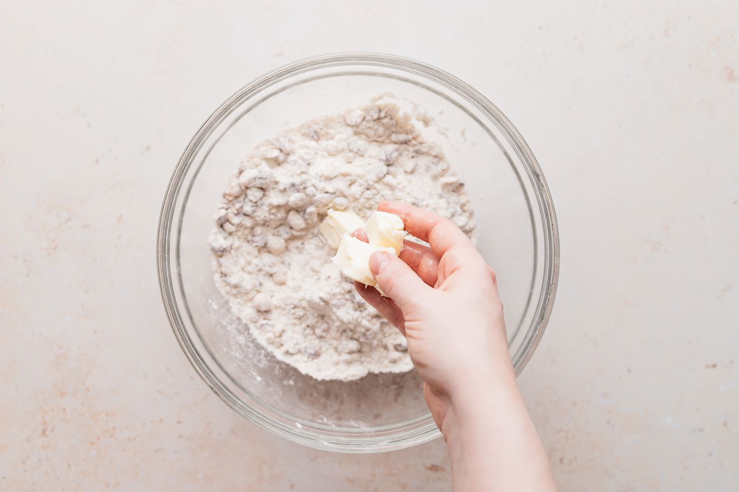 Cutting the butter into the dry ingredients to make a snowball cookie recipe.