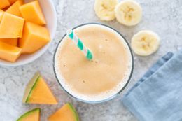 Overhead view of a quick and easy cantaloupe smoothie with cantaloupe and banana around the cup.