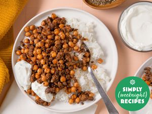 A plate with rice topped with seasoned chickpeas and minced meat, with yogurt on the side, Simply Weeknight Recipes label in view