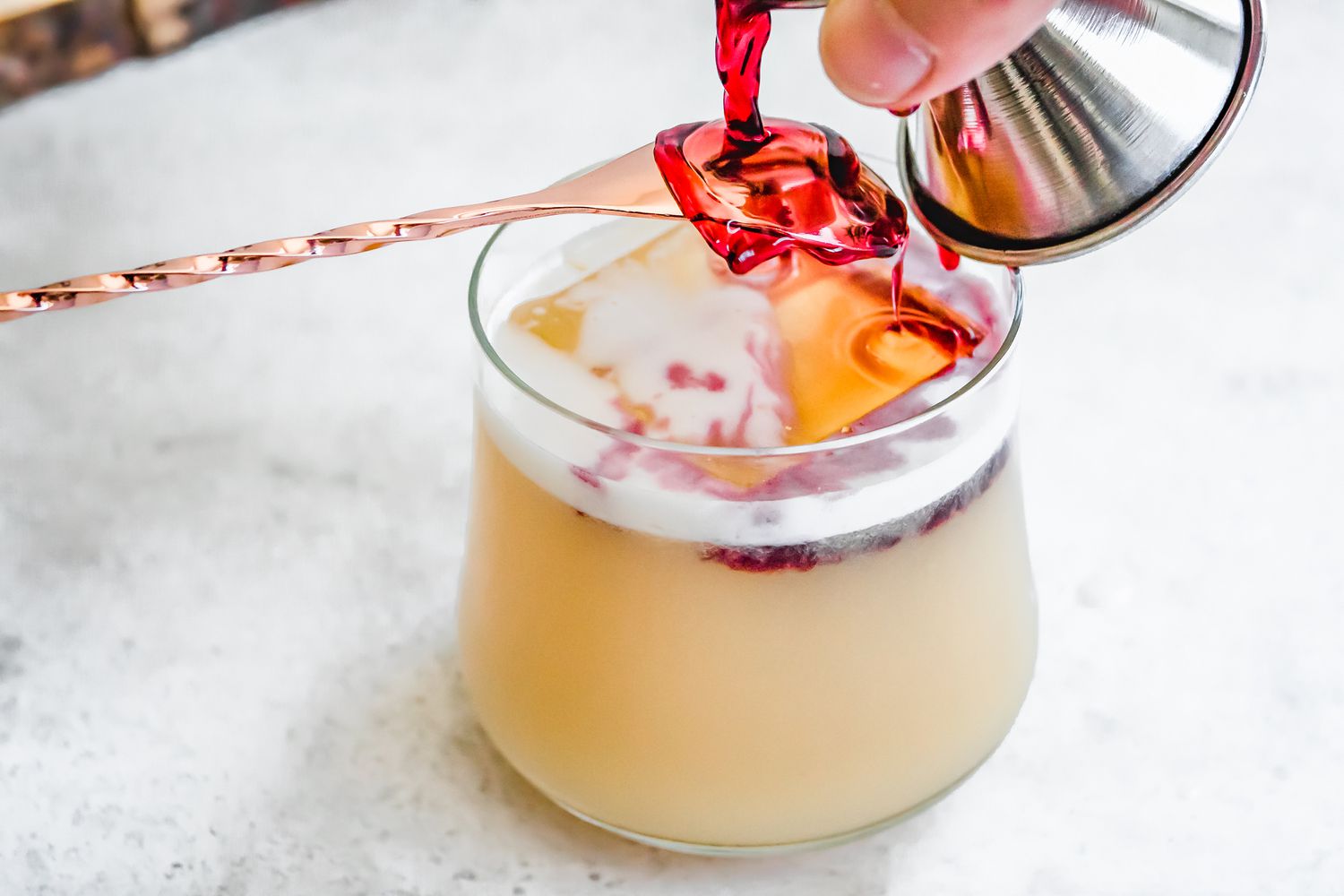 Red Wine Layer for New York Sour Cocktail Carefully Poured onto the Back of a Bar Spoon to Trickle into the Glass 