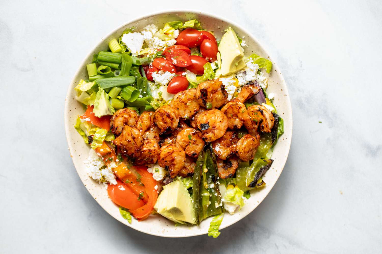 Bowl of Grilled Shrimp Salad with Shrimp, Avocados, Cherry Tomatoes, and Cotija Cheese