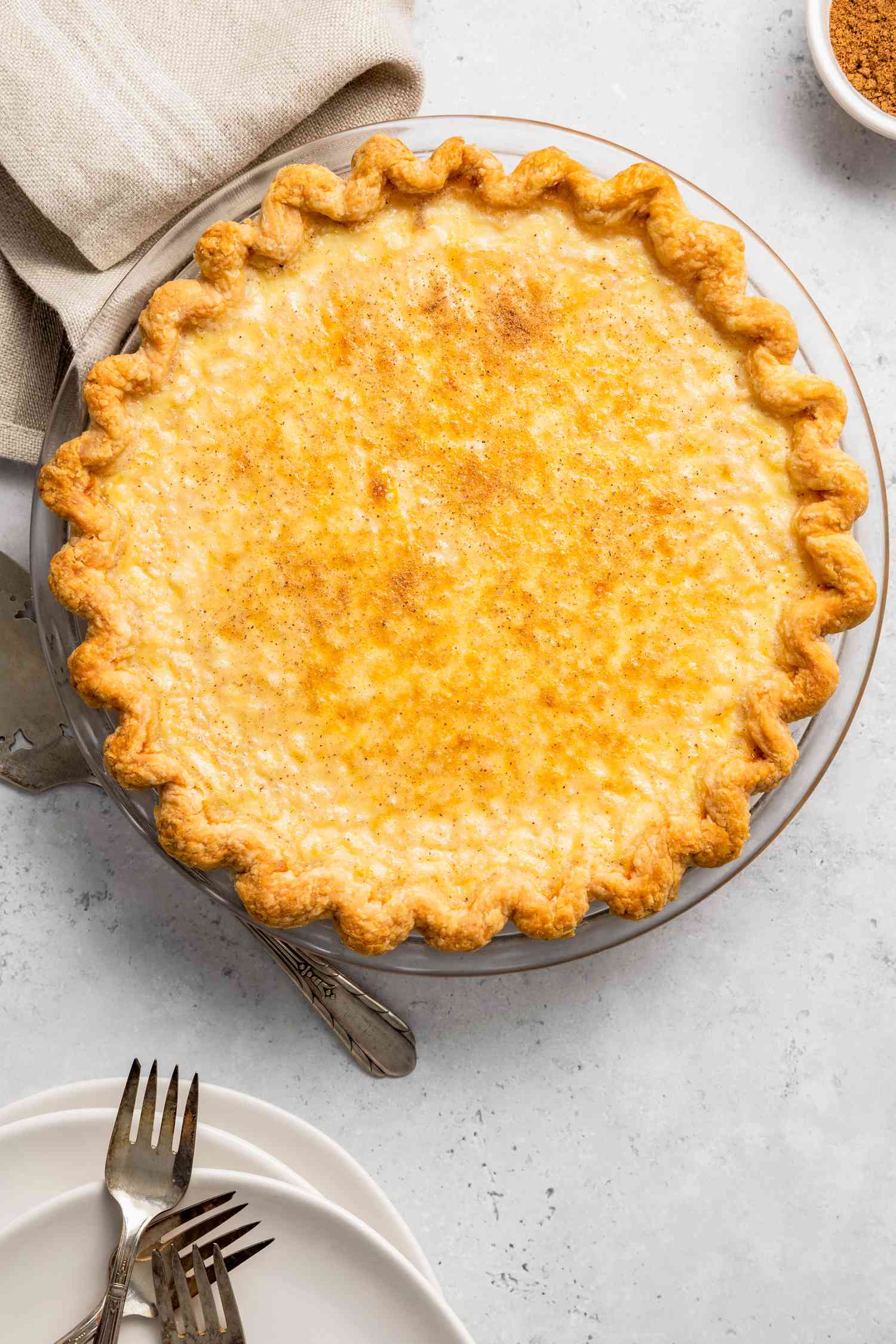 Egg Custard Pie Next to a Pie Server and Plates with Forks 